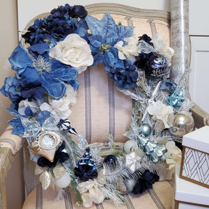 Floral Christmas wreath includes magnolia, poinsettia, hydrangeas in  shades of blue and white.