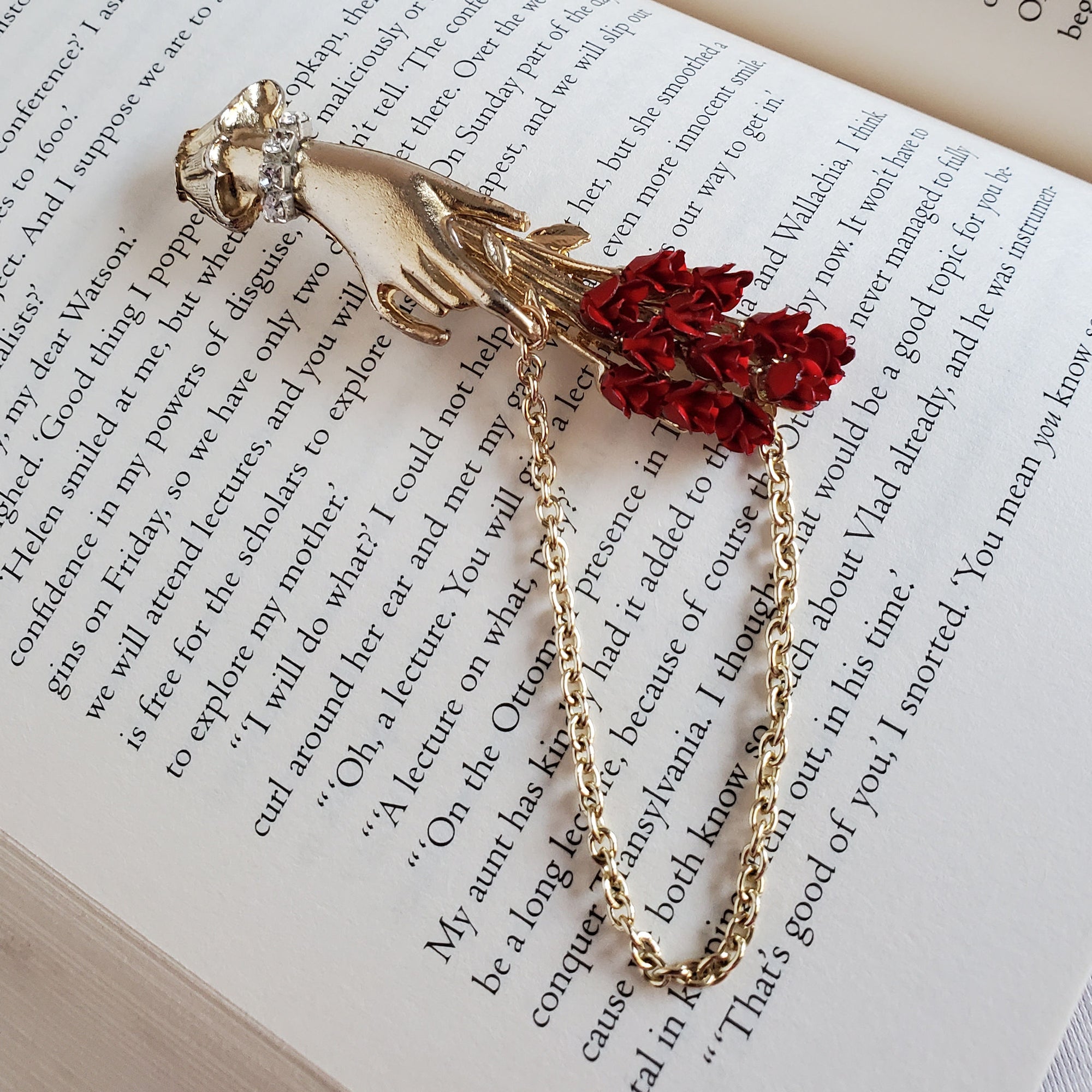 Victorian Style woman's Hand Brooch  holding a bouquet of red roses with a chain accent