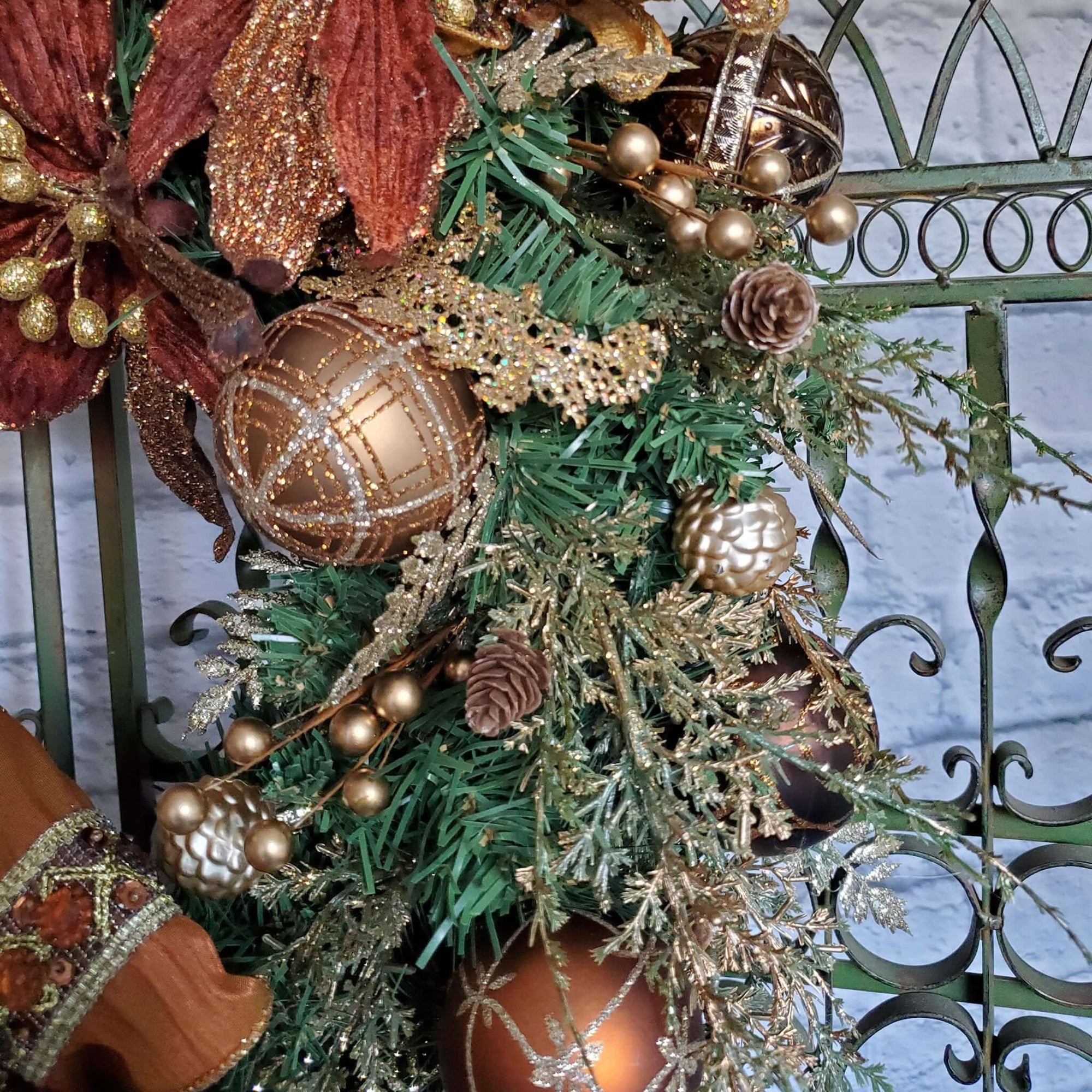 Round, one inch gold pinecone ornaments are scattered throughout the wreath.