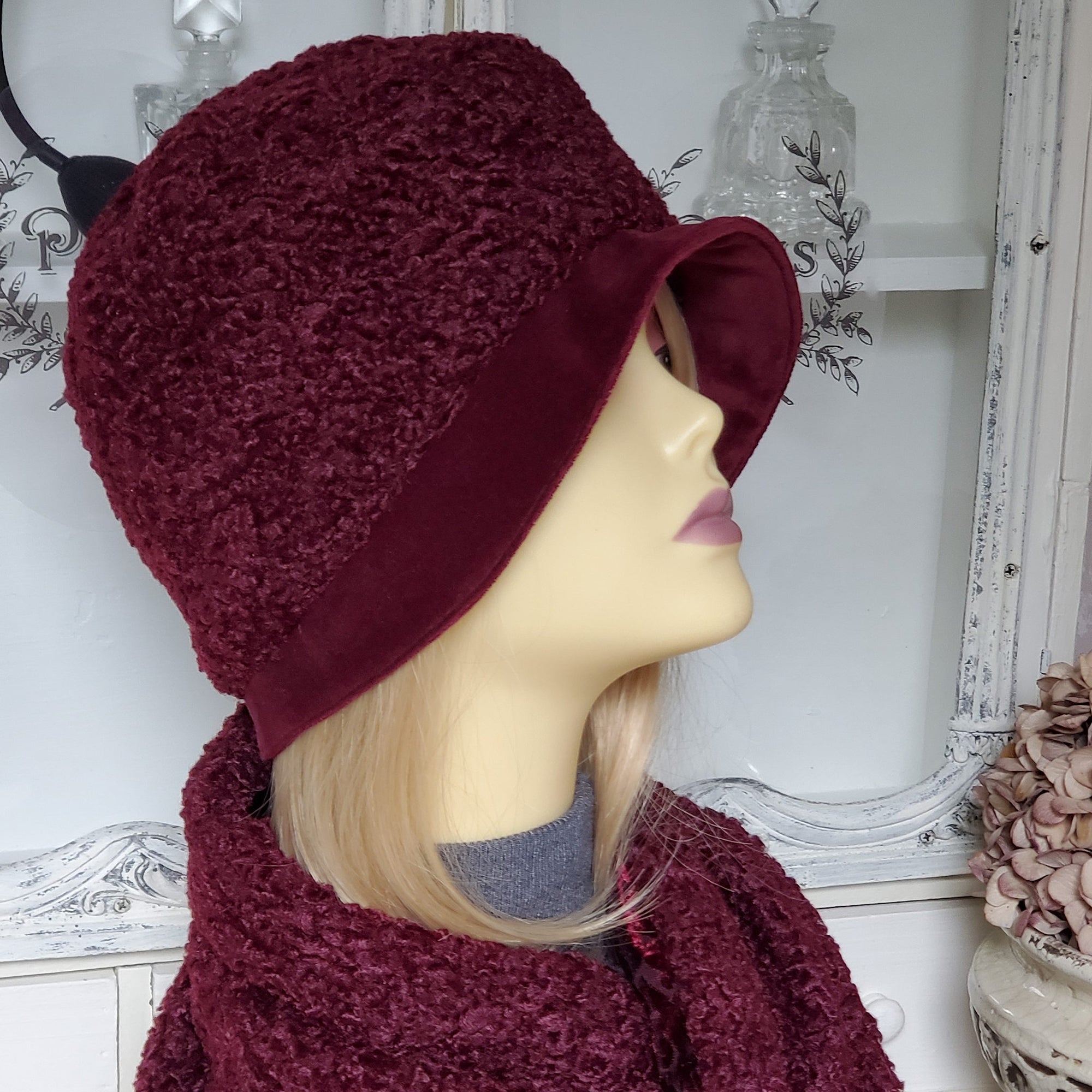 Model is wearing a burgundy Persian lamb cloche with a matching Persian lamb scarf.